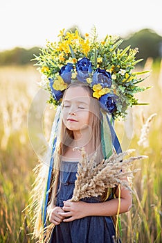 Girl carries fluttering blue and yellow flag of Ukraine in field