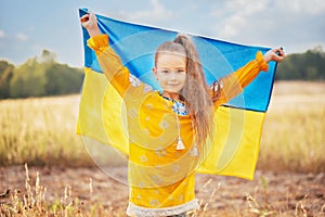 Girl carries fluttering blue and yellow flag of Ukraine in field