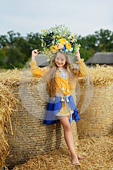 Girl carries fluttering blue and yellow flag of Ukraine in field