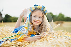 Girl carries fluttering blue and yellow flag of Ukraine in field