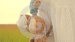 A girl carries in her hand toy teddy bear with medical mask in summer park. child holds his beloved teddy bear in