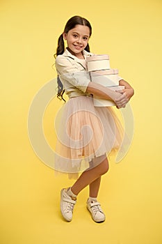 Girl carries pile boxes. Create shopping list to save money. Back to school season great time to teach budgeting basics