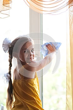 A girl carrying out home inspections, washes dirty windows with a rag and window cleaner. Focus on hands, dirty and clean window,