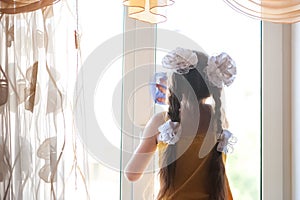 A girl carrying out home inspections, washes dirty windows with a rag and window cleaner. Focus on hands, dirty and clean window,