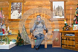 Girl on carved wooden throne in Christmas decorations