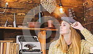 Girl in casual outfit with kepi in wooden vintage interior. Tomboy concept. Lady on calm face in plaid clothes looks