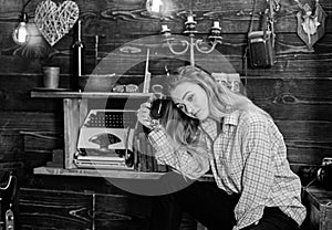 Girl in casual outfit sits in wooden vintage interior. Girl tomboy relax with glass with mulled wine in house of