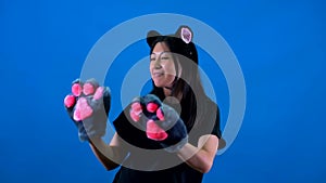 Girl with cat paws dancing on a blue background