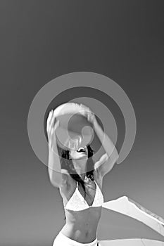 Girl catching beach ball on sunny beach in Spain. Black and white.