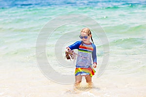 Girl catching fish. Kids fishing on tropical beach