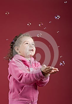 Girl catching soap bubbles photo