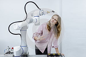 Girl caucasoid education electronic robotic arm on table at class room. learning innovation robot electronic for future AI. System