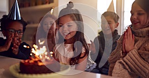 Girl Celebrating Birthday With Group Of Friends At Home Being Given Cake Decorated With Sparkler