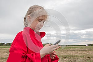 Girl with cell phone and cloudy sky