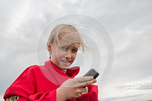 Girl with cell phone and cloudy sky