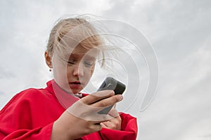 Girl with cell phone and cloudy sky