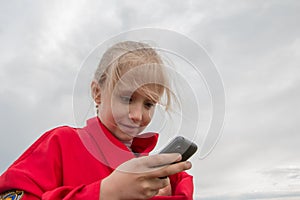 Girl with cell phone and cloudy sky