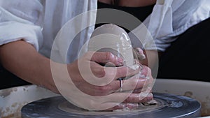 A girl ceramic artist makes a vase on the potter's wheel. Women artists are creating, succeeding, feminism in action