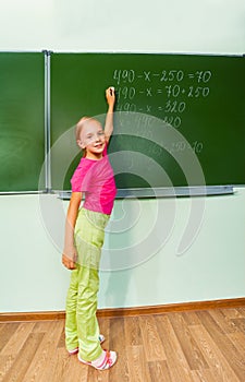 Girl with chalk in hand writing equation