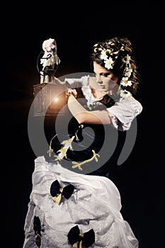 Girl with chamomile and lamp in the hands  in vintage dress