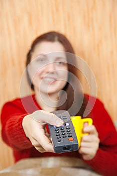 Girl changing channels with clicker at home