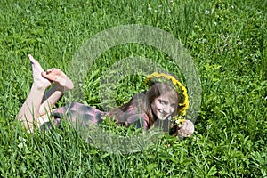 Girl in a chaplet lying from meadow