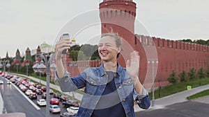 Girl chating on facetime on the phone in front of Kremlin. Russia