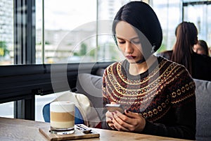 Girl checking mail while sitting in cafe