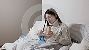 Girl checking temperature with a thermometer. Common cold, disease. Concept of healthcare and medical care