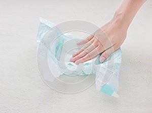 The girl checks the absorbency of a baby nappy with a napkin, close-up