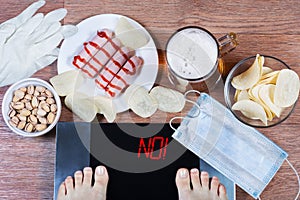 Girl checks her weight after quarantine. Digital scales with word no on screen. Concept of unhealthy lifestyle.