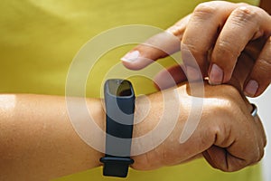 Girl checks pulse on fitness bracelet or activity tracker pedometer on wrist