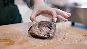 Girl chef checks finger pokes meat steak