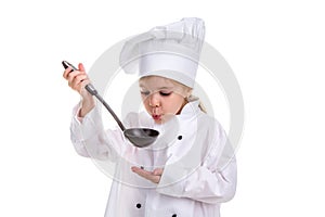 Girl chef white uniform isolated on white background. Holding black ladle and blowing to it. Looking at the ladle