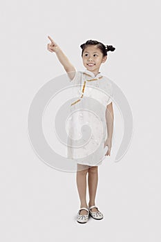 Girl in cheongsam smiling and pointing with finger. Conceptual image