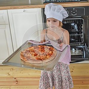 The girl child cooks pizza in the oven photo without filter