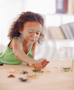 Girl, child development and toy insect for science in living room of home for education or growth. Study, education and