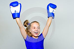 Girl child happy winner with boxing gloves posing on grey background. Feminist movement. She feels as winner. Upbringing