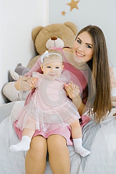 Girl is a child in her mother`s arms. Happy smiling mom and daughter