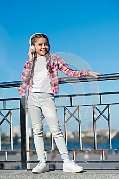 Girl child listen music outdoors with modern headphones. Kids headphones tested and ranked best to worst. Enjoy sound