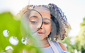 Girl child, magnifying glass and plants in garden, backyard or park in science, study or outdoor. Young female kid, lens
