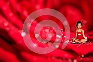 Girl child meditating on macro rose flower