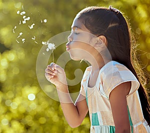 Girl, child and nature dandelion flower blowing for wish, dream and magic in garden on vacation in spring. Kid, park and