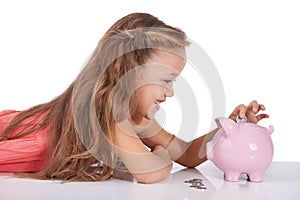 Girl child, piggy bank and coins for saving, studio or thinking with smile for investing by white background. Confused