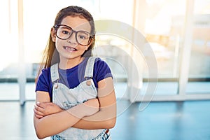 Girl child, portrait and glasses for growth, arms crossed happy for development at home. Kid, smile or eyewear with