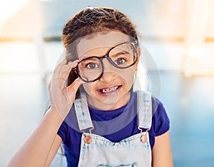 Girl child, portrait, glasses and growth for spring, happy and development at home. Kid, smile or eyewear with youth