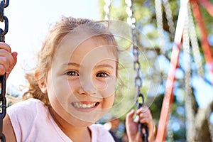 Girl, child and portrait on swing for playing in park with happiness, wellness and outdoor in South Africa. Kid, face