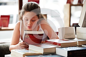 Girl child, reading book and education, story for knowledge or entertainment with customer in bookshop. Library, store