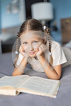 Girl child reads a book in the room