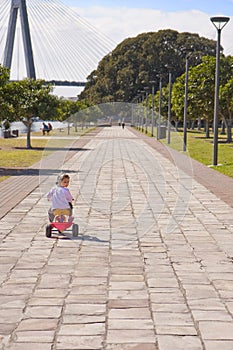 Girl child riding kids trike on path